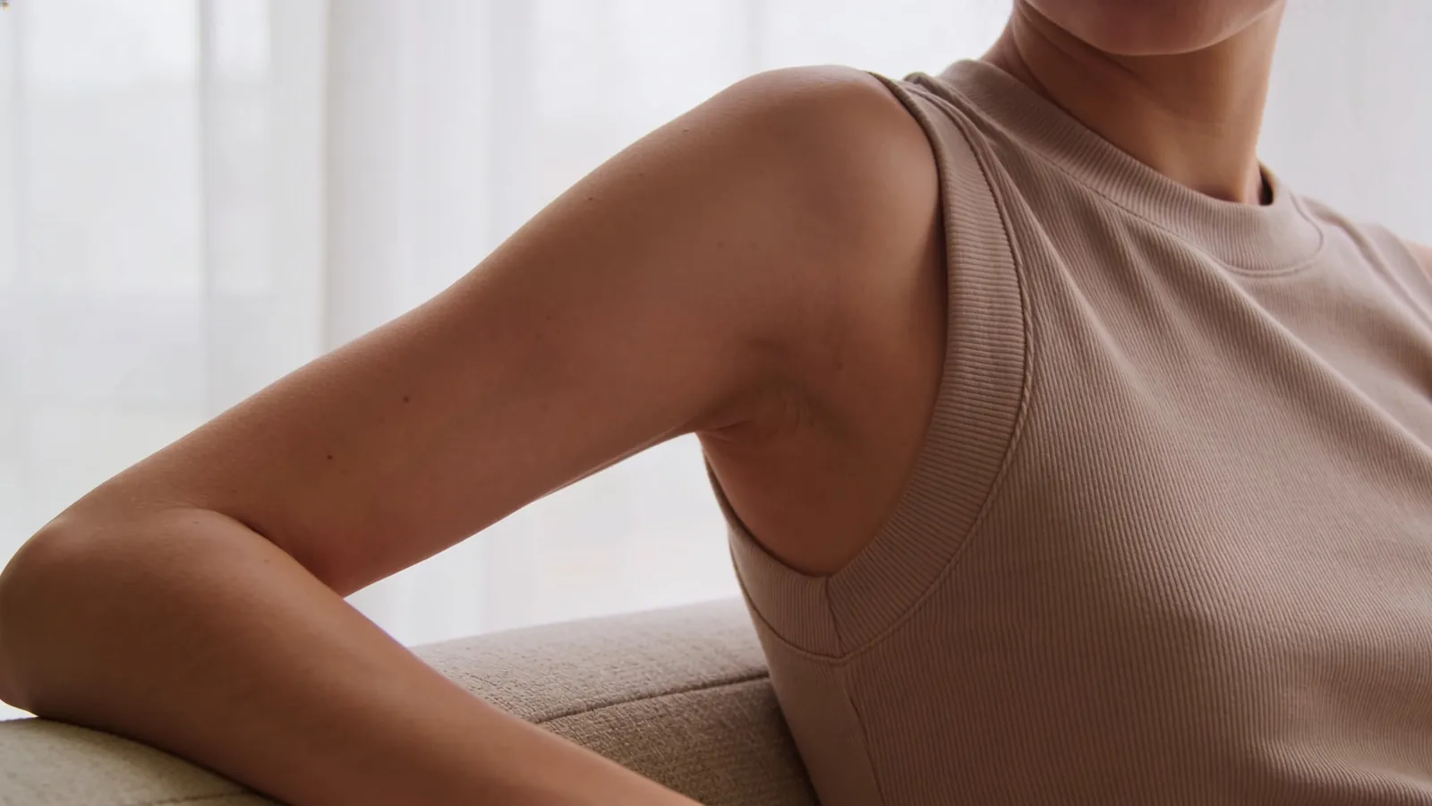Woman in a sleeveless top, side view, arm relaxed