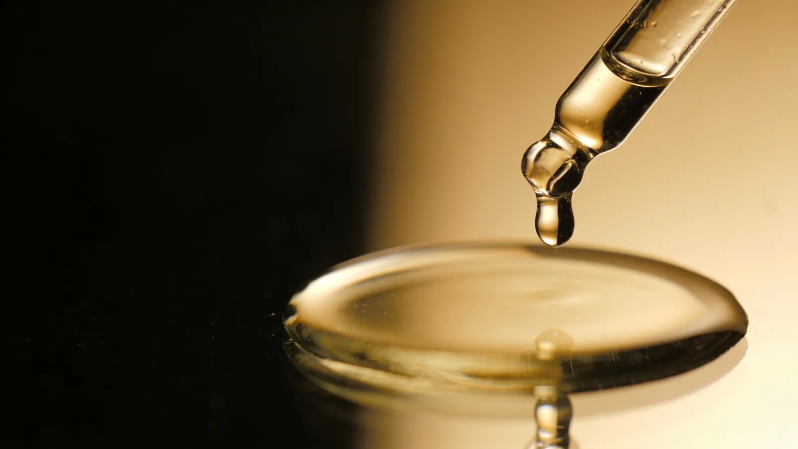 Clear liquid falling from a glass dropper, illustrating a facial peel solution