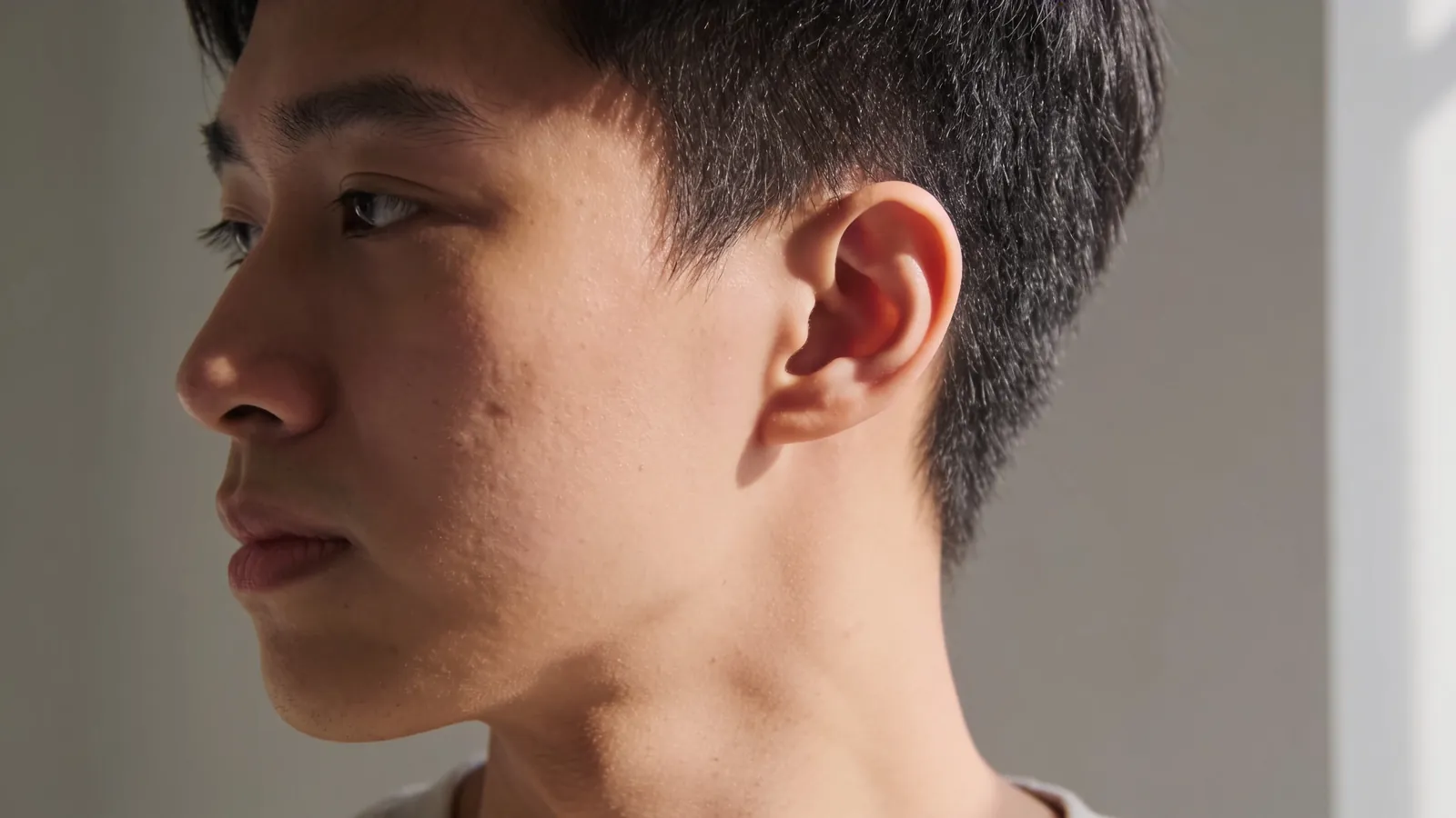 Young man in three-quarter view, soft light on his cheek