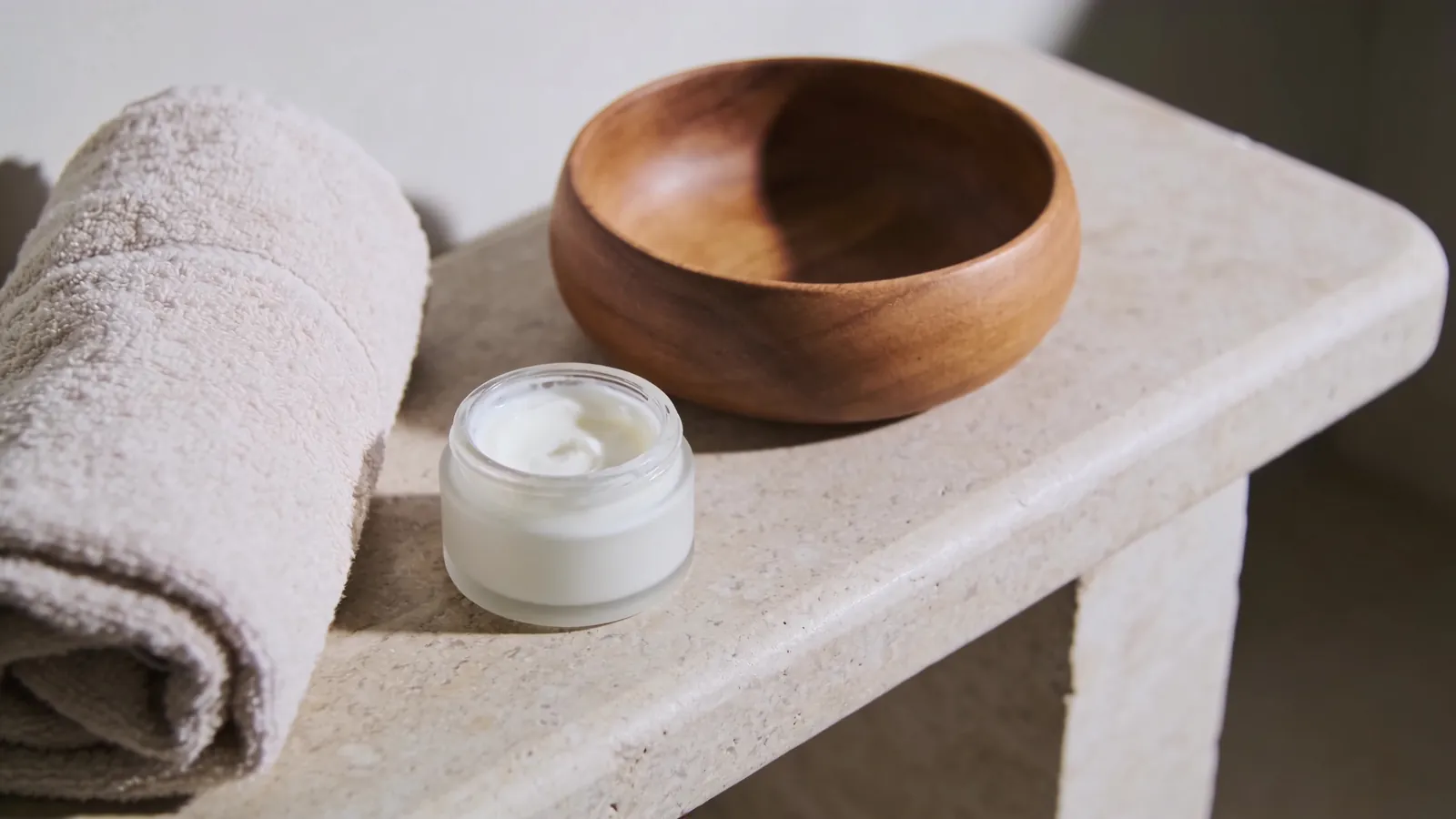 Body cream, towel and wooden bowl