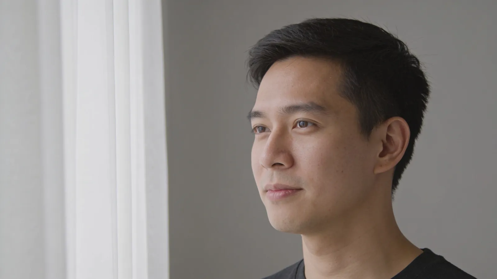 Man in his thirties with short dark hair in soft light