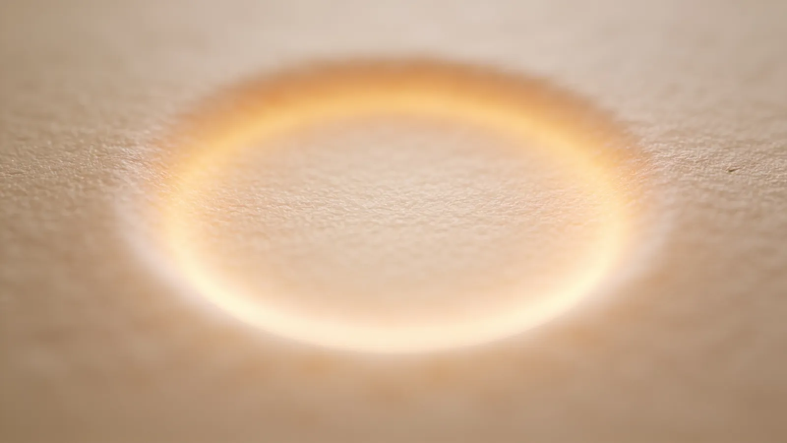 Smooth beige surface with a soft circular warm glow